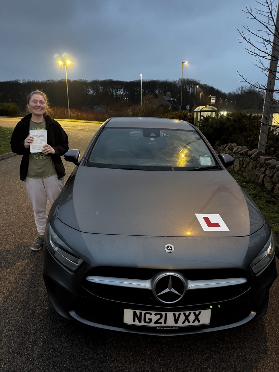 Successful Blue Drive pupil beside the Mercedes-Benz training car